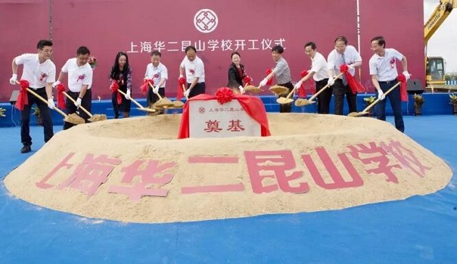 People shovel sand around a sign