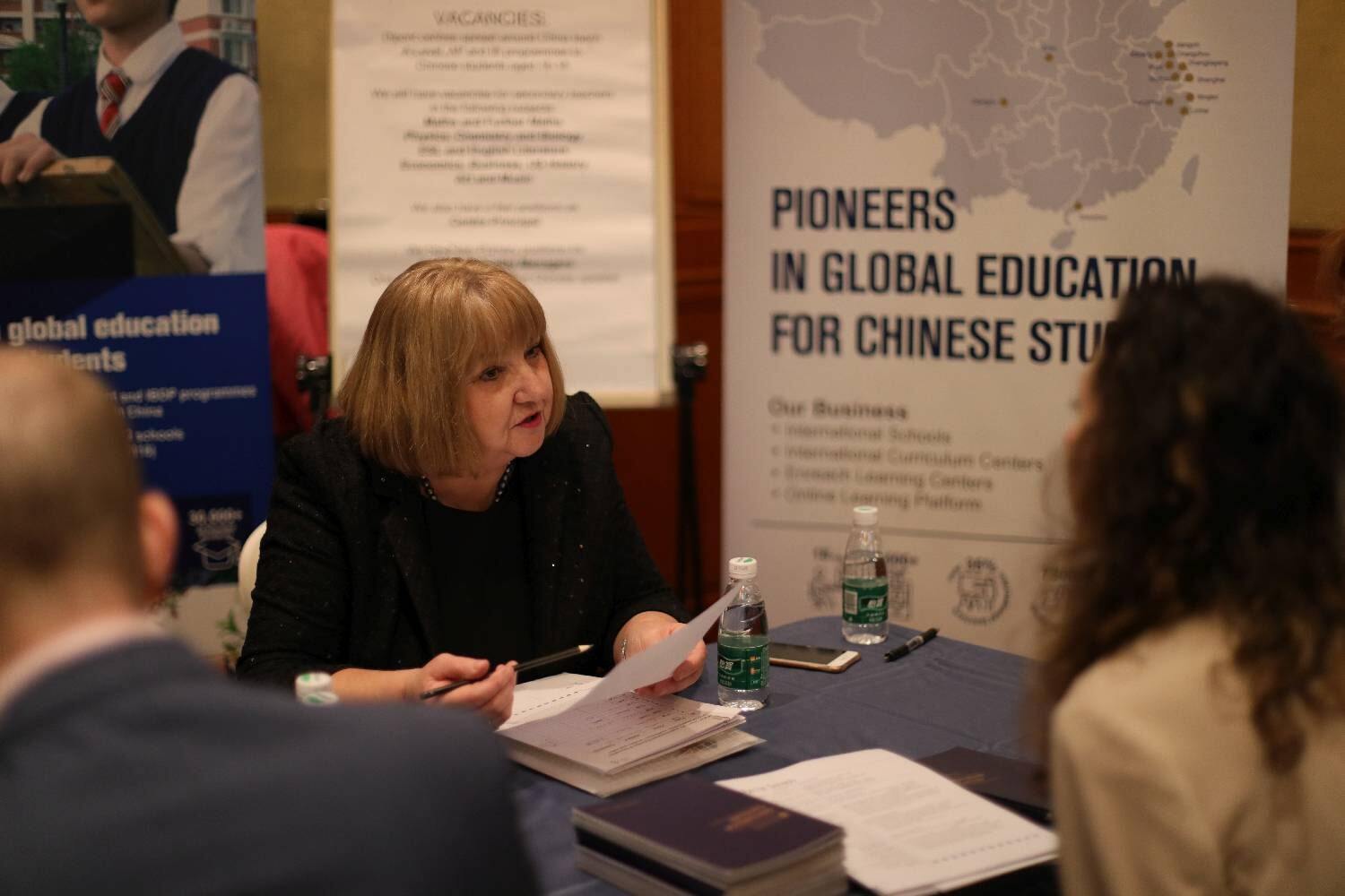 Two women speak to each other across a table 