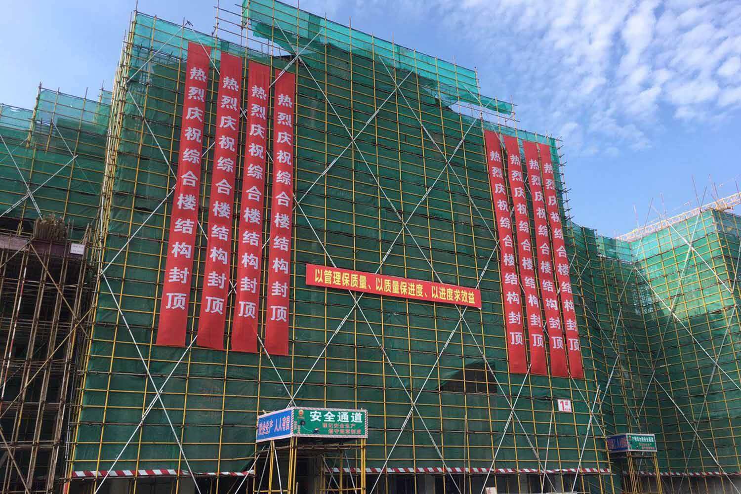 The exterior of a building covered in scaffolding and green netting