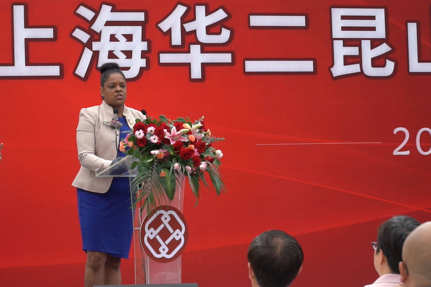 Carol Santos, founding head of the school, gives a speech at a podium