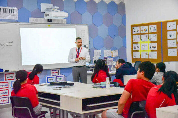 A teacher standing in front of a class of students