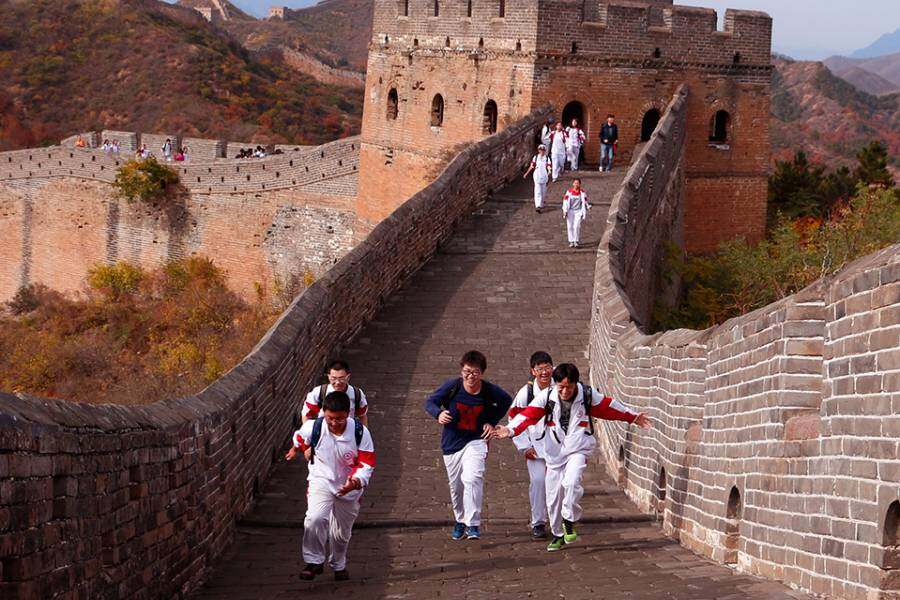 School children run on the Great Wall of China