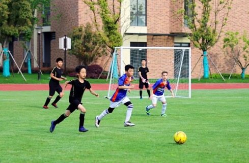 Pupils play football at King's College School Hangzhou