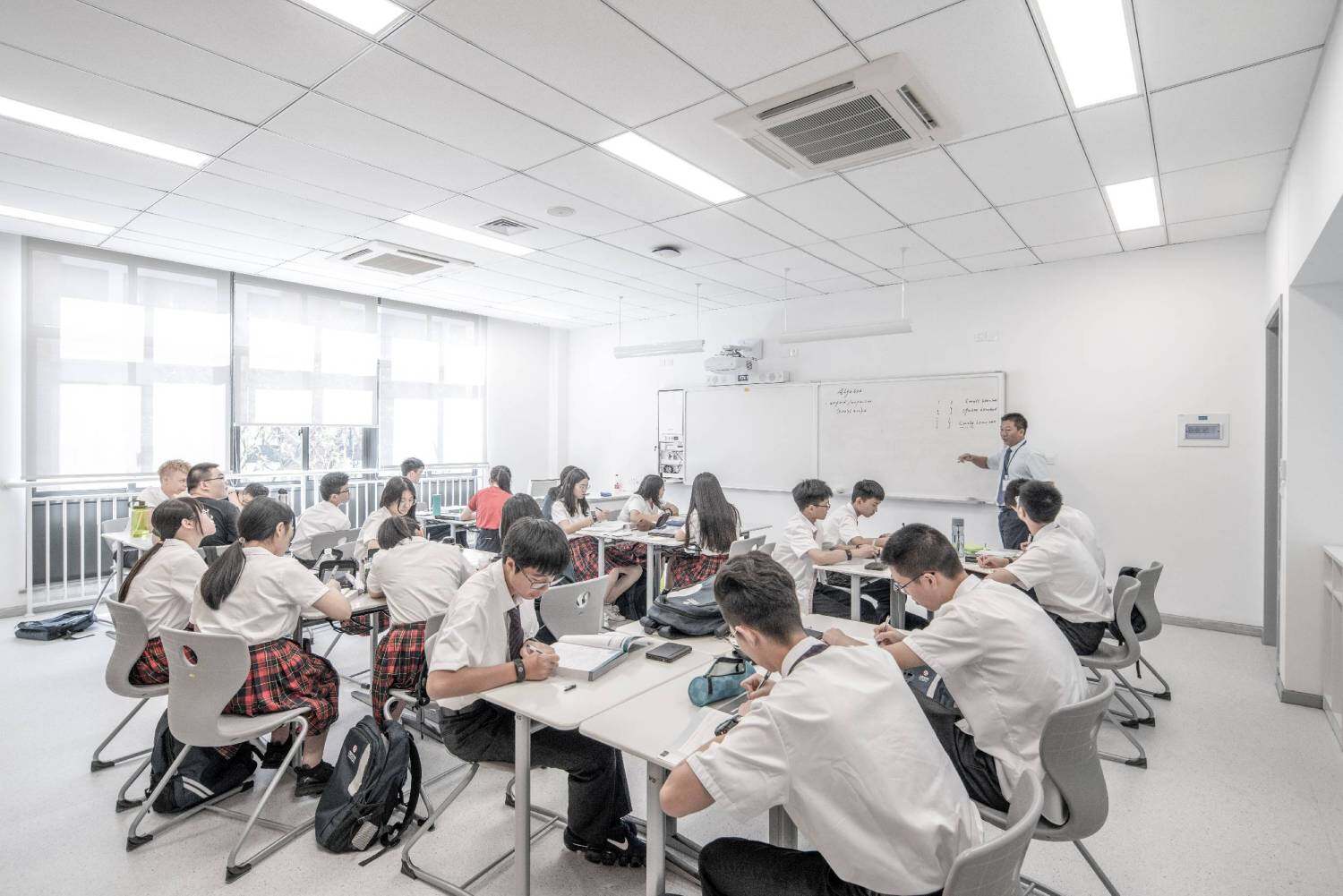 A teacher standing in front of a classroom of students